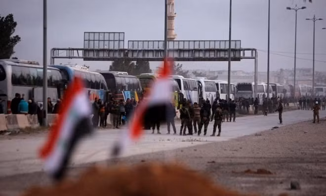 Các tay súng ở Đông Ghouta xếp hàng lên xe bus đi sơ tán. Ảnh: AMN
