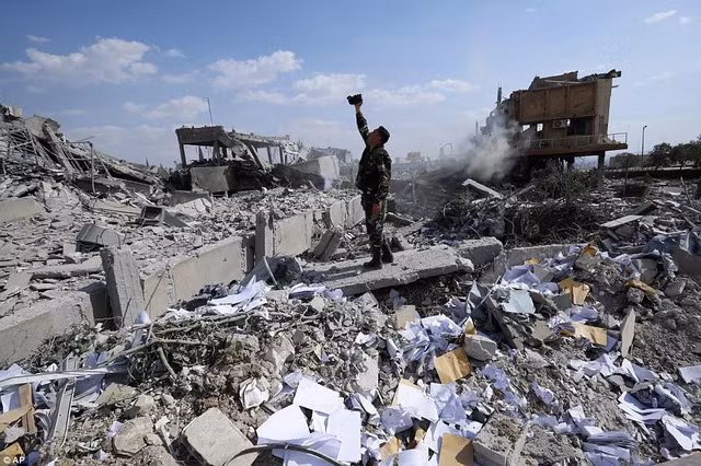 Một binh sĩ Syria kiểm tra thiệt hại tại trung tâm khoa học vừa bị đánh sập. Ảnh: ITN