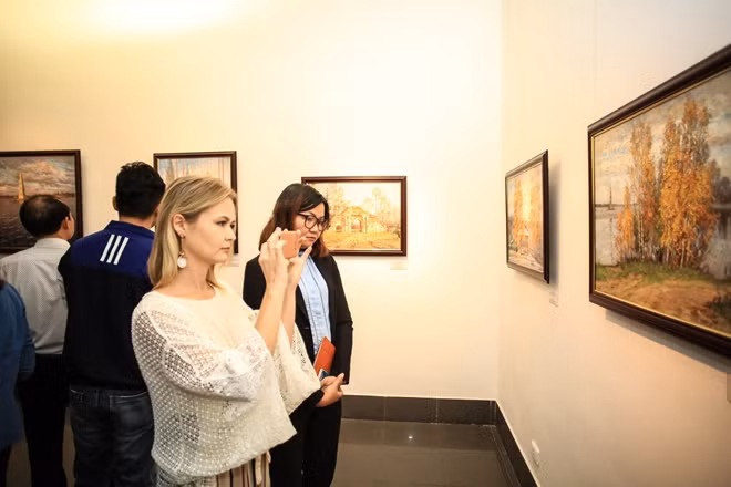 Một vị khách người Nga tới ngắm nhìn những bức tranh tuyệt đẹp về phong cảnh đất nước.
