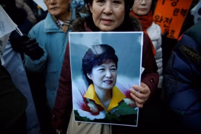 Một người ủng hộ giữ bức chân dung của Tổng thống Hàn Quốc Park Geun-hye trong một cuộc biểu tình phản đối luận tội bà gần tòa án Hiến pháp ở Seoul, Hàn Quốc. Ảnh: Reuters