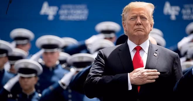 Tổng thống Mỹ Donald Trump đặt tay lên ngực chào cờ trong một sự kiện ở căn cứ quân sự. Ảnh: AP