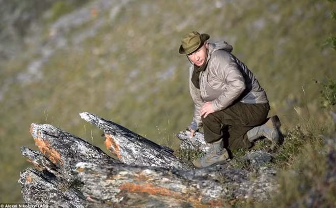 Tổng thống Putin ngồi cạnh một mỏm đá cao để quan sát thiên nhiên Nga.