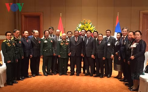 Tổng Bí thư, Chủ tịch nước Lào Bounnhang Vorachith chụp ảnh lưu niệm với các đại biểu dự buổi gặp mặt. Ảnh: VOV