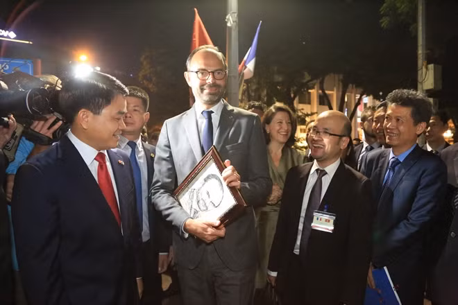 Trong chuyến đi dạo, Thủ tướng Pháp đã nhận một món quà ý nghĩa từ Chủ tịch UBND thành phố Hà Nội là bức tranh chân dung của ông do một hoạ sĩ đường phố vẽ. Thủ tướng Édouard Philippe tỏ ra rất hào hứng với bức tranh...