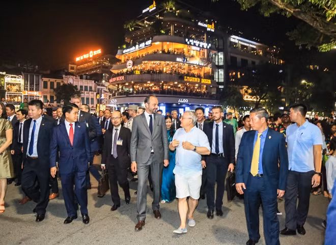 Thủ tướng Pháp trò chuyện cùng một người dân gần Quảng trường Đông Kinh Nghĩa Thục.
