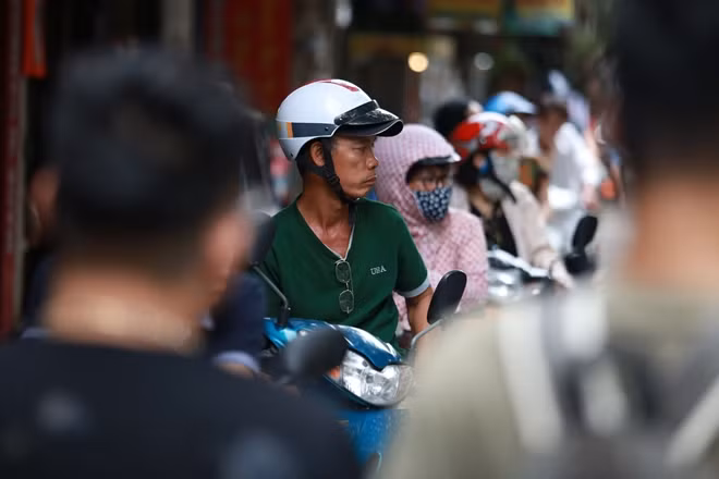 Khuôn mặt căng thẳng của một phụ huynh chờ con tại điểm thi trường THCS Việt Nam - Angieri.