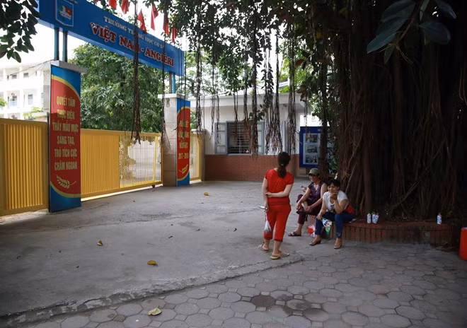 Chỉ còn lác đác phụ huynh ngồi chờ con ở cổng trường THCS Việt Nam - Angieri.