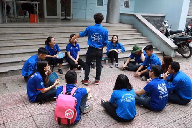 Các bạn sinh viên tình nguyện thư giãn trong khi chờ đợi các thí sinh làm bài tại điểm thi trường THCS Việt Nam -Angieri.
