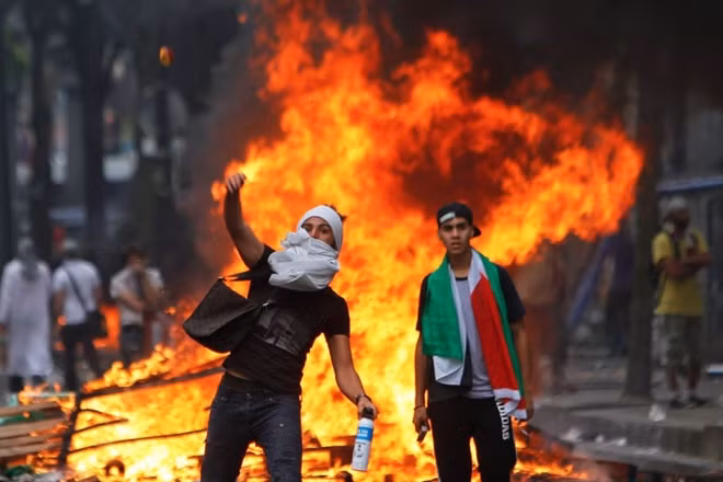 Thanh niên Palestine ném đồ vật về phía Israel trong cuộc biểu tình hôm 9-12. Ảnh: Reuters