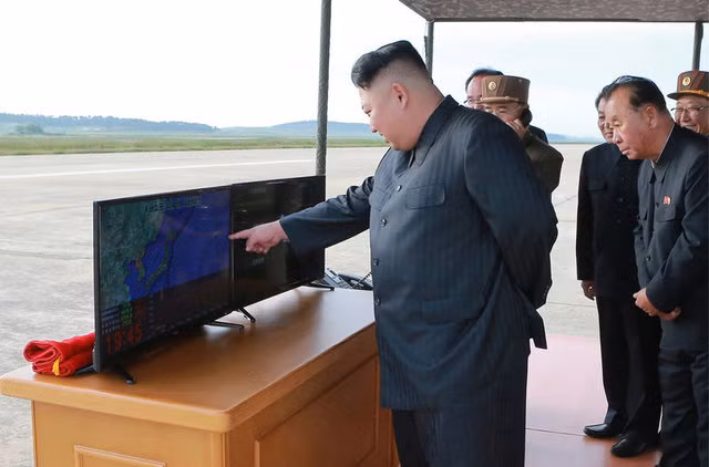 Ông Kim Jong-un kiểm tra lộ trình của quả tên lửa qua một màn hình TV.