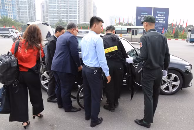 Các chiến sĩ CSCĐ và Cảnh vệ giúp đỡ một quan khách tàn tật di chuyển vào khu hội nghị bằng xe lăn.