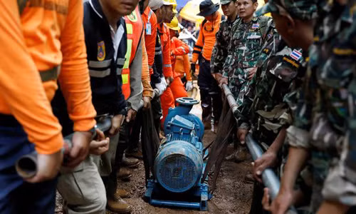 Đội cứu hộ chuyển một máy bơm tới khu vực hang Tham Luang, nơi đội bóng nhí Thái Lan mắc kẹt. Ảnh: Reuters.