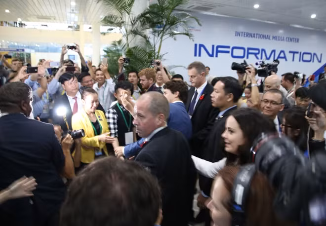 Thủ tướng Canada bước vào Trung tâm báo chí APEC trong sự chào đón nồng nhiệt của những phóng viên và tình nguyện viên nữ.