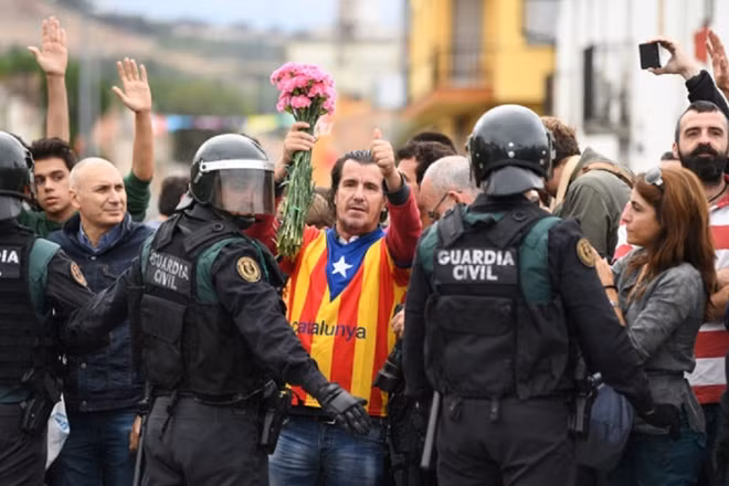 Người Catalonia bên hàng rào cảnh sát trong cuộc trưng cầu ý dân hôm 1-10. Ảnh: AP