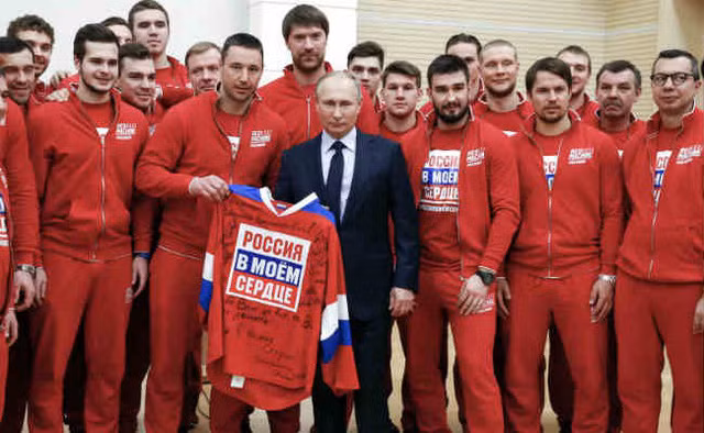 Tổng thống Putin bên cạnh các vận động viên Nga. Ảnh: RT Tổng thống Putin bên cạnh các vận động viên Nga. Ảnh: RT