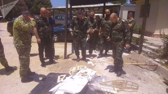 Binh lính Syria đứng cạnh một UAV bị bắn hạ đêm 30-6. Ảnh: Sputnik