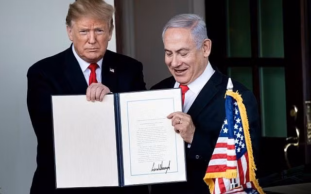 Tổng thống Mỹ Trump và Thủ tướng Israel Benjamin Netanyahu bên văn kiện mà ông Trump vừa kí. Ảnh: Reuters