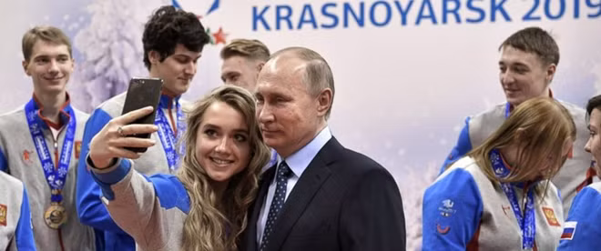 Một người trẻ Nga chụp ảnh cùng ông Putin. Ảnh: Getty Images