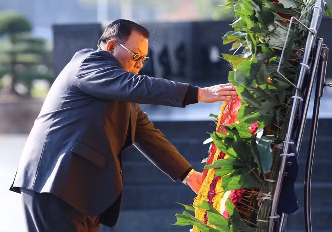 Tổng Bí thư, Chủ tịch nước Lào Bounnhang Vorachith chỉnh vòng hoa trước khi vào Lăng viếng Chủ tịch Hồ Chí Minh.