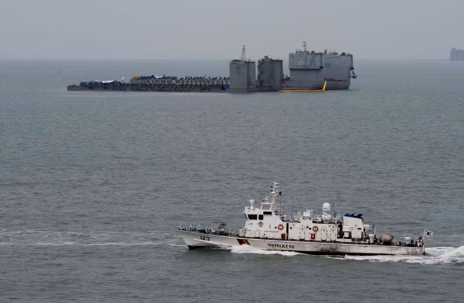 Sáng 22-3, quá trình trục vớt phà Sewol đã bắt đầu. Công việc được tiến hành sớm hơn dự kiến đến gần 2 tuần sau nhiều bước kiểm tra. Ảnh: Reuters