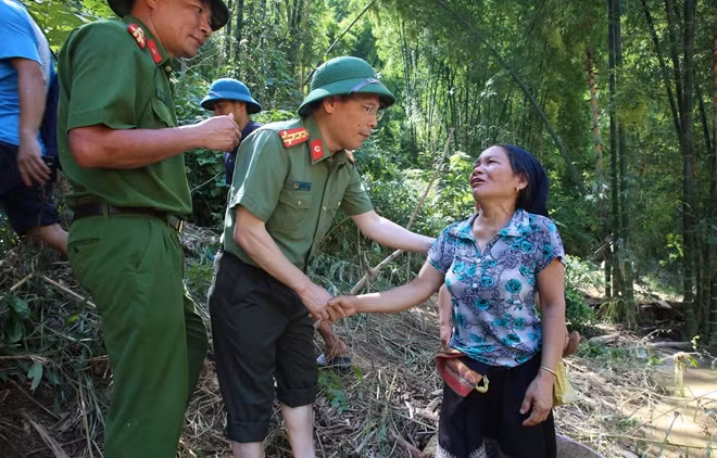 Trên đường vào bản, Đoàn gặp nhiều người dân địa phương đang đi bộ ra ngã ba sông Luồng chờ tin về người thân mất tích hoặc chờ nhận quà cứu hộ của các đơn vị, cá nhân. Trong ảnh Đại tá Trần Thanh Phong động viên, chia sẻ khó khăn cùng một phụ nữ bản Sa Ná sau cơn bão số 3.