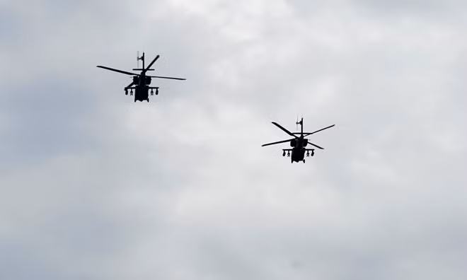 Lục quân Mỹ điều 4 trực thăng tấn công AH-64 Apache tới sự kiện. Chúng tách thành hai biên đội và bay với giãn cách lớn. Đây là mẫu máy bay yểm trợ đường không hiện đại của Mỹ, được xem là ác mộng của thiết giáp mặt đất nếu rơi vào tầm bắn của nó.