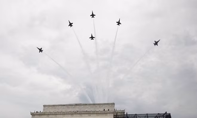 Dàn tiêm kích F/A-18 của phi đội Blue Angels xả khói và biểu diễn đội hình trên bầu trời thủ đô Washington. Blue Angels được thành lập vào năm 1946 và có đội ngũ phi công được tuyển chọn từ hai quân chủng của Mỹ là Hải quân và Thủy quân Lục chiến.