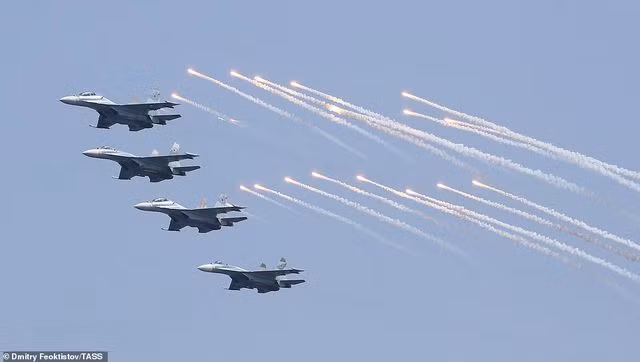Ngoài tàu chiến, phi đội tiêm kích hải quân Nga cũng xuất hiện tại lễ duyệt binh. Trong ảnh là dàn 4 máy bay Su-30 phiên bản hải quân thả pháo sáng khi bay qua lễ đài.