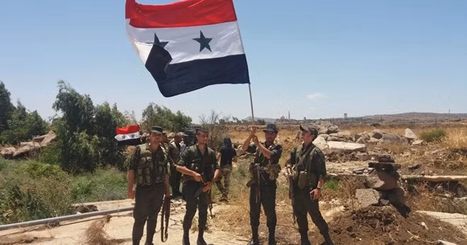 Binh sĩ Syria vẫy cờ trên phần Cao nguyên Golan mà nước này kiểm soát. Ảnh: Haaretz