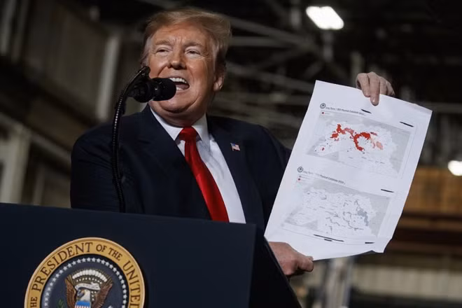 Ông Trump và hai tấm bản đồ thể hiện việc IS bị đánh đuổi khỏi Syria và Iraq. Ảnh: AP