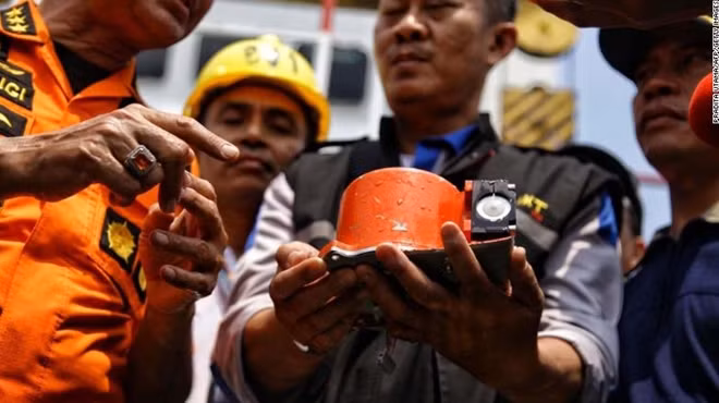 Một bức ảnh từ cơ quan truyền thông Indonesia "detikcom" cho thấy các quan chức đang cầm trên tay một phần của thiết bị ghi dữ liệu chuyến bay Lion Air của JT 610, sau khi nó được vớt lên từ biển Java hôm 1-11. Ảnh: CNN