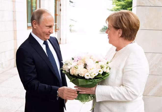 Tổng thống Putin tặng hoa bà Merkel tại cuộc gặp hồi tháng 5. Ảnh: RIA