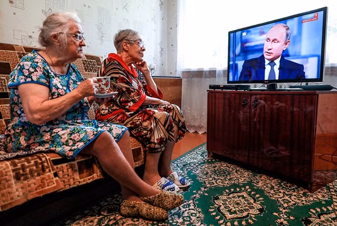 Người Nga theo dõi ông Putin qua TV. Ảnh: ITN