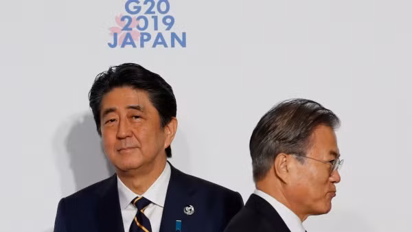 Tổng thống Hàn Quốc Moon Jae-in bước qua Thủ tướng Nhật Bản Shinzo Abe tại Thượng đỉnh G20. Ảnh: AP