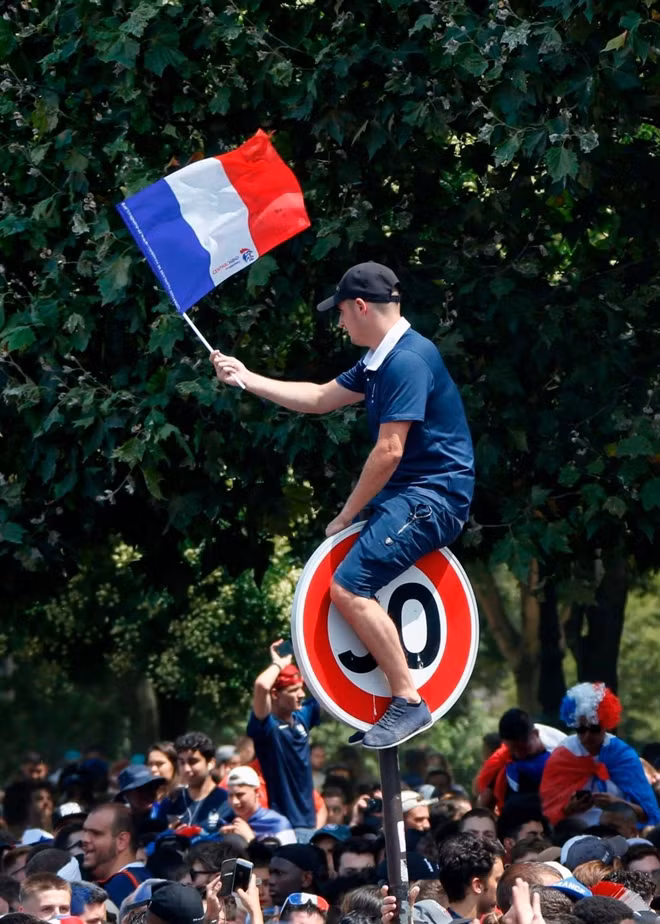 Một người đàn ông ngồi lên cột biển báo hạn chế tốc độ ở Paris. Có lẽ, vào thời điểm này, những chiếc biển báo thế này không còn tác dụng nào nữa bởi chẳng có xe cộ nào len được vào các tuyến đường chính ở Paris.