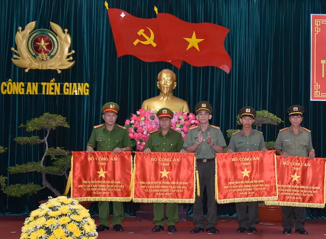 Đại tá Nguyễn Hữu Trí, Giám đốc Công an Tiền Giang trao Cờ thi đua của Bộ Công an tặng các đơn vị.