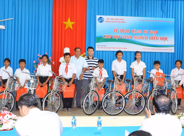 Đại tá Kiên Rịnh và các mạnh thường quân trao tặng xe đạp cho các em học sinh nghèo.