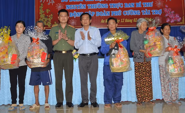 Đại diện Báo Công an nhân dân và đại diện lãnh đạo Tỉnh uỷ Kiên Giang trao quà cho người nghèo huyện An Minh.