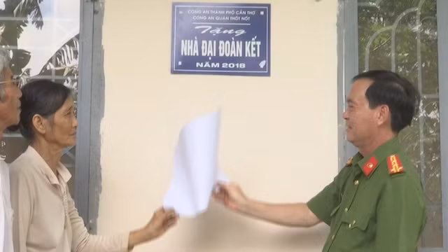 Đại tá Bùi Trọng Thế - Phó Giám đốc Công an TP Cần Thơ trao nhà cho gia đình bà Nguyệt.