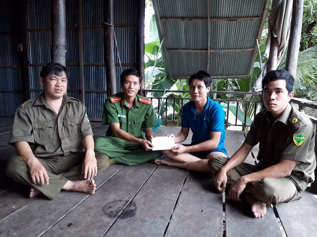 Đoàn viên thanh niên Công an huyện Tam Nông trao tiền cho Công an viên xã.