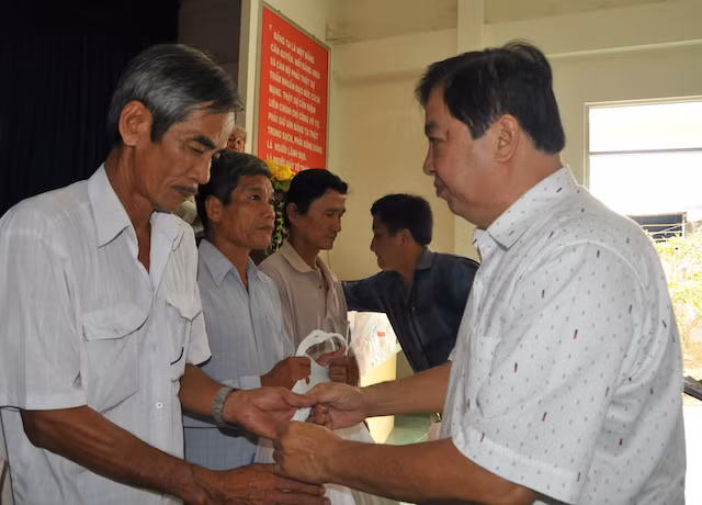 Đại diện gia đình ông Võ Văn Bảy trao quà cho người dân.