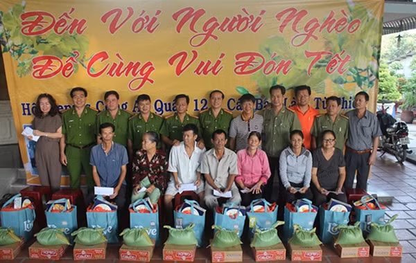 Cán bộ chiến sĩ Công an quận 12 và kỷ lục gia Đinh Công tường trao quà cho bà con nghèo tại Củ Chi.