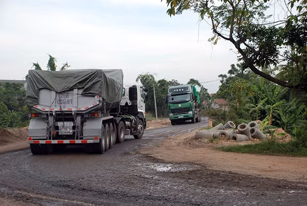 Đoạn đê nhỏ hẹp khiến hai chiếc xe hạng nặng khó khăn tránh nhau.