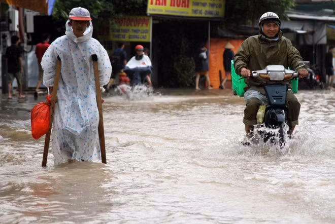 Ông Cao Văn Quyên (53 tuổi) bị tật ở chân trái trong lần tai nạn phải chống nạng trên đường ngập về nhà. Tối hôm trước, ông ở nhà mình lúc trời mưa lớn nên các cháu tới đón đưa đi nơi khác. "Nghe hàng xóm bảo nước vào nhà nên tôi trở về kiểm tra thế nào", ông Quyên nói. Ông Cao Văn Quyên (53 tuổi) bị tật ở chân trái trong lần tai nạn phải chống nạng trên đường ngập về nhà. Tối hôm trước, ông ở nhà mình lúc trời mưa lớn nên các cháu tới đón đưa đi nơi khác. "Nghe hàng xóm bảo nước vào nhà nên tôi trở về kiểm tra thế nào", ông Quyên nói.