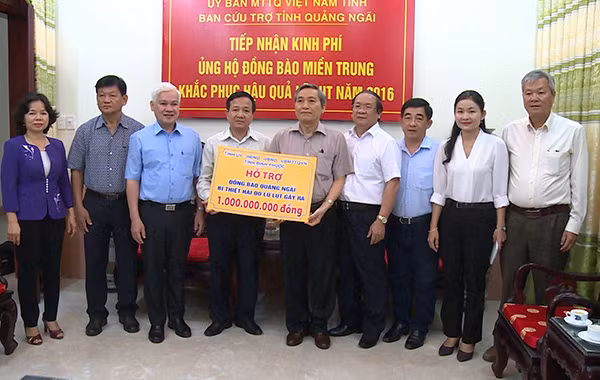 Đoàn công tác tỉnh Bình Phước (bên trái) trao số tiền hỗ trợ 1 tỉ đồng cho tỉnh Quảng Ngãi.