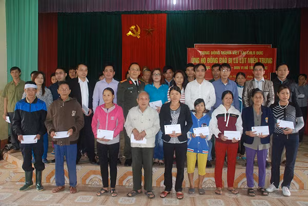 Đại diện Cộng đồng người Việt tại CHLB Đức và Báo CAND tặng quà tới đồng bào vùng lũ Hương Khê – Hà Tĩnh (mỗi suất trị giá 1 triệu đồng).