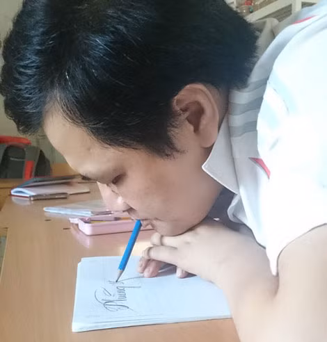Bằng sự khổ luyện, thầy Trường có thể viết chữ rất đẹp bằng miệng.