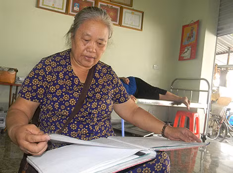 Bà Liên bên cuốn sổ ghi chép lại thông tin những vụ TNGT trong 10 năm qua mà bà đã cứu hộ, giúp đỡ người TNGT.