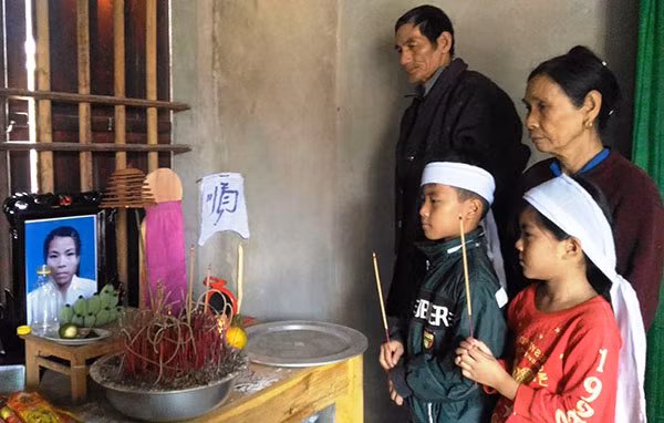 Hai anh em An và Nhàn cùng ông bà nội bên bàn thờ mẹ.