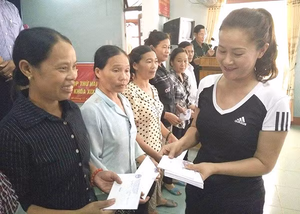 Chị Nguyễn Thị Lợi trao tiền hỗ trợ của bà con Việt kiều ở tỉnh Tachov cho người dân vùng lũ xã Quảng Hải.